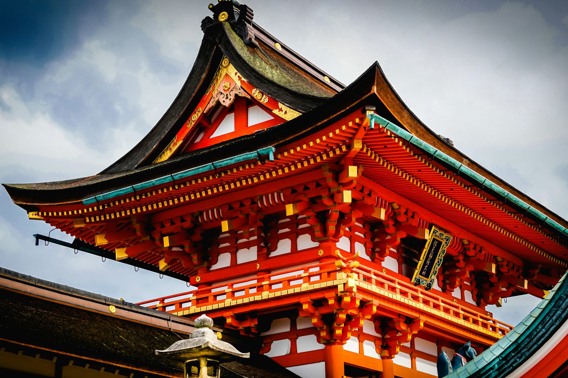 A red Japanese shrine against a moody sky